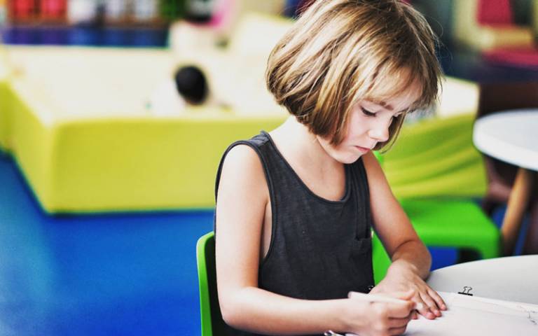 Child writing in classroom