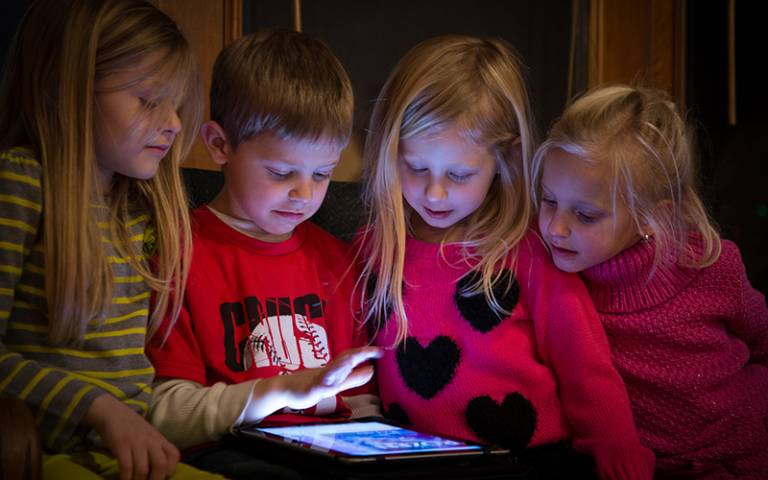 Children captivated reading a tablet