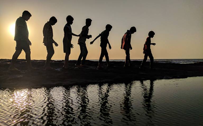 Children walking by water