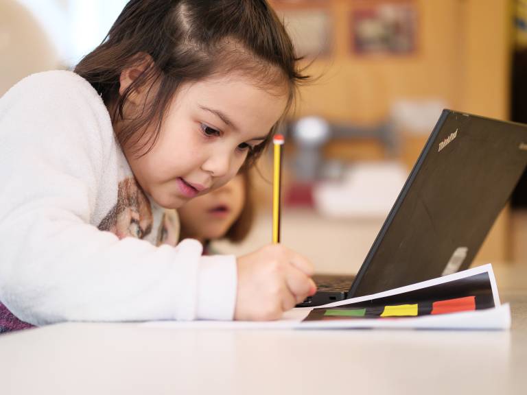 Child drawing looking at laptop. Credit: UCL Digital Media.