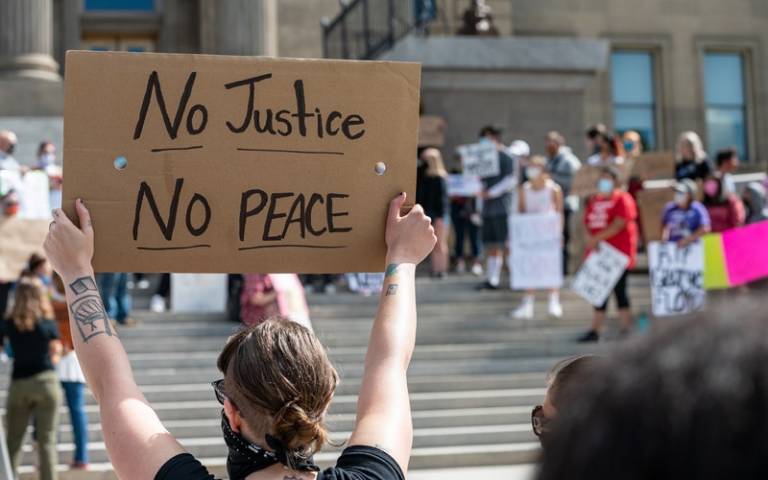 Person holding no justice, no peace sign. Image: Brett Sayles via Pexels