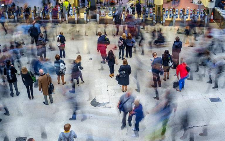 Commuters walk around a London train station; some are made blurry by movement. Image credit: Chris Mann / Adobe Stock.