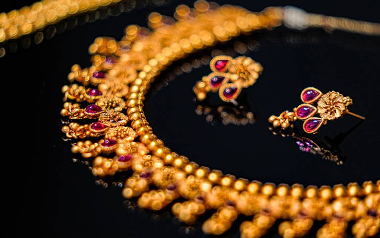 Gold necklace and matching earrings. Image: Vaibhav Nagare via Unsplash