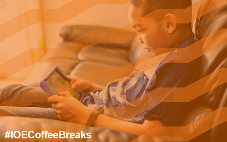 Boy slouches on a sofa while playing an educational game on a tablet #IOECoffeeBreaks