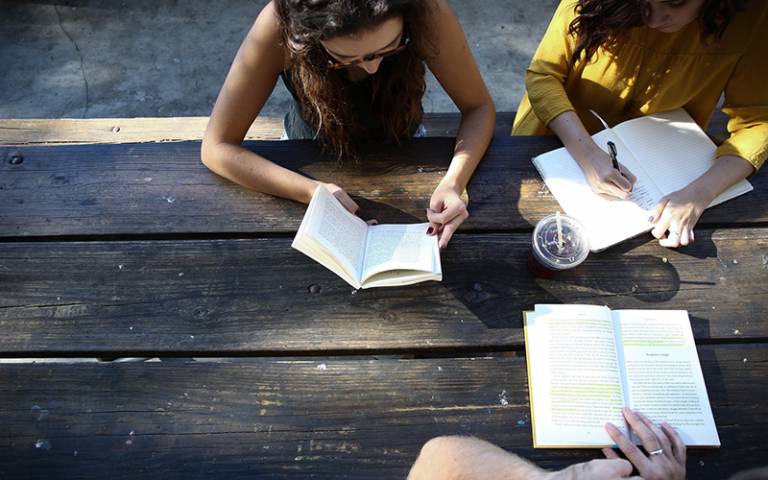 International students studying outside on wooden table. Image: Alexis Brown via Unsplash