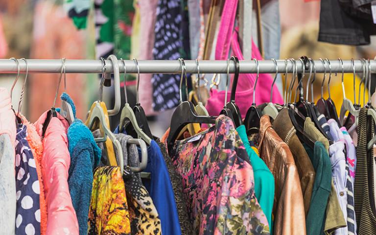 Vintage clothes hanging on clothes hanger on a rail. Photo by HildaWeges / Adobe Stock.