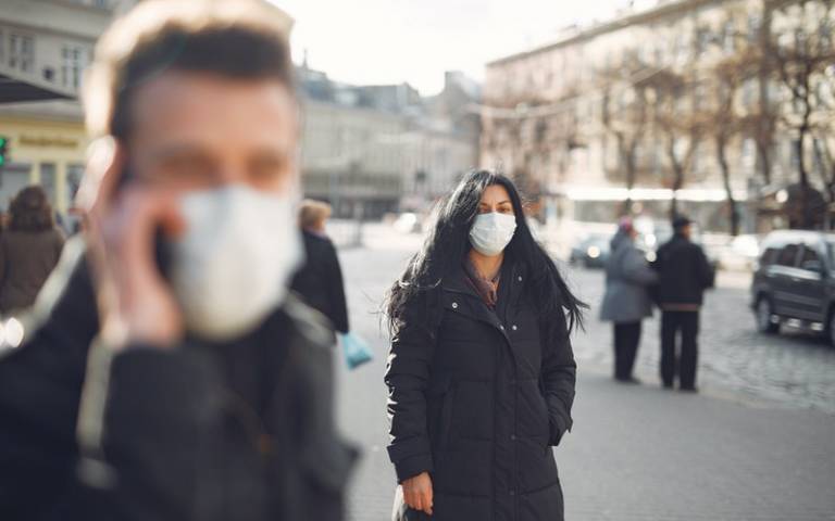 Woman standing in street with mask on. Image: Gustavo Fring via Pexels