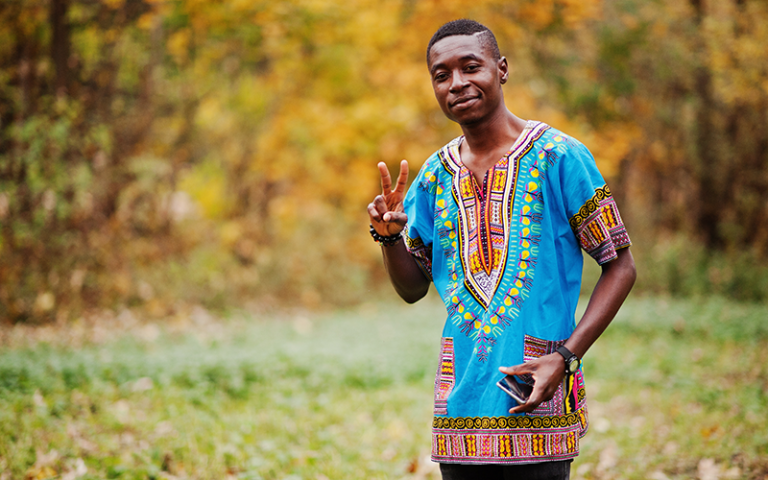 Young man wearing a traditional Ghanaian shirt poses for a photo. Credit: AS Photo Family / Adobe Stock