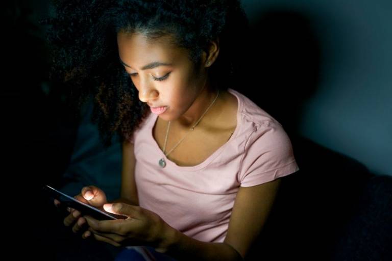 Lonely girl texting on mobile phone late at night. Photo: iStock