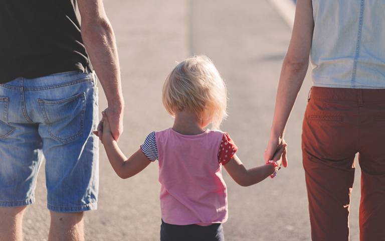 Girl holding parent's hands