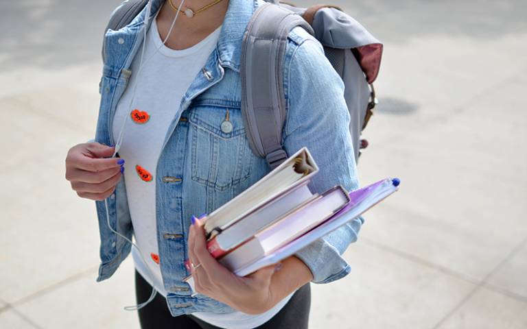 Student carrying books. Image: Element5 Digital via Unsplash