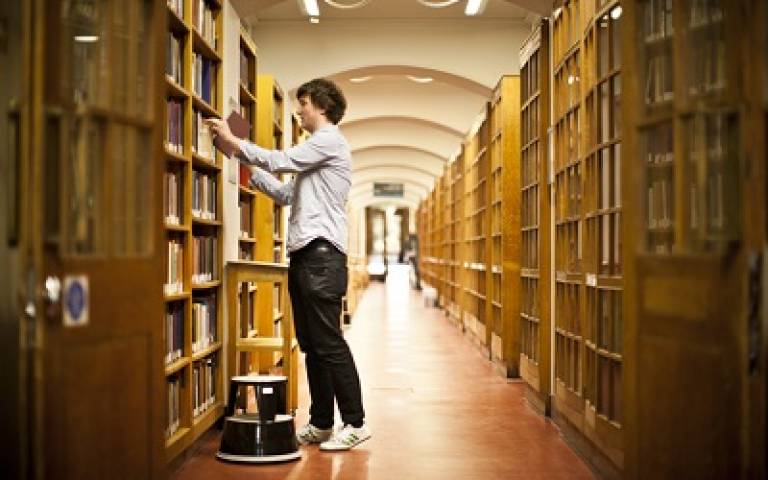 Man taking book from library shelf