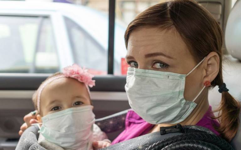 Woman and child sitting in taxi with masks on. Image: David Veksler via Unsplash