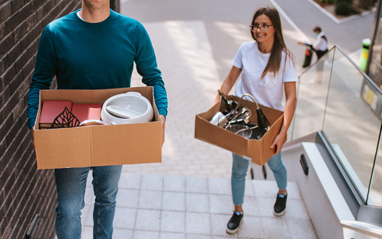 Two people carrying boxes of belonging to move into university. Credit: Dragica via Adobe Stock