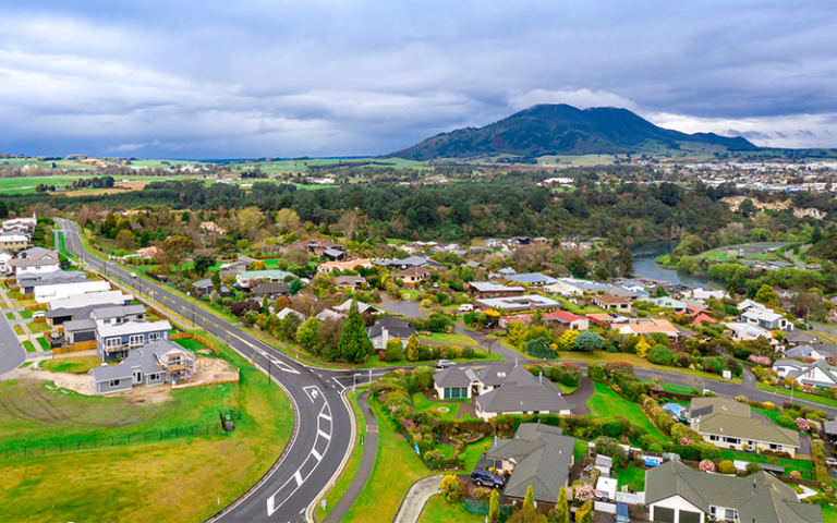 Aerial view of a New Zealand town with a blue mountain in the distance. Image: Krzysztof Bargiel / Adobe Stock.