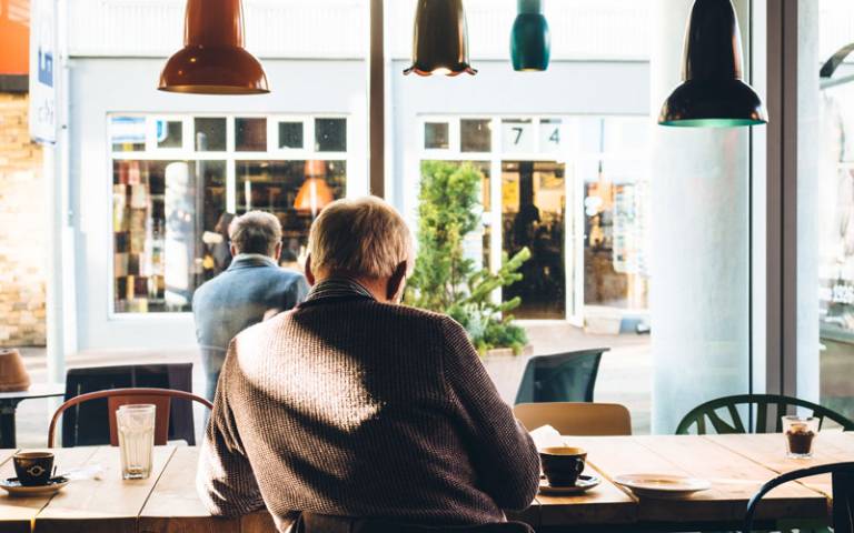 Older man sitting alone in a cafe