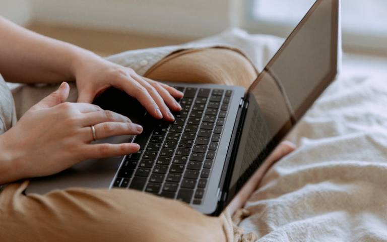 Person using their laptop and sitting on bed. Image: Image: Tatiana Syrikova via Pexels