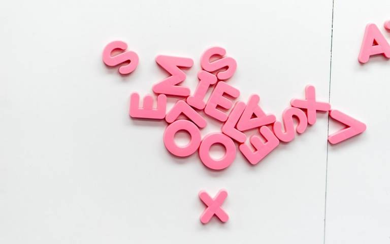 Pink letters of the alphabet mixed up on a white background