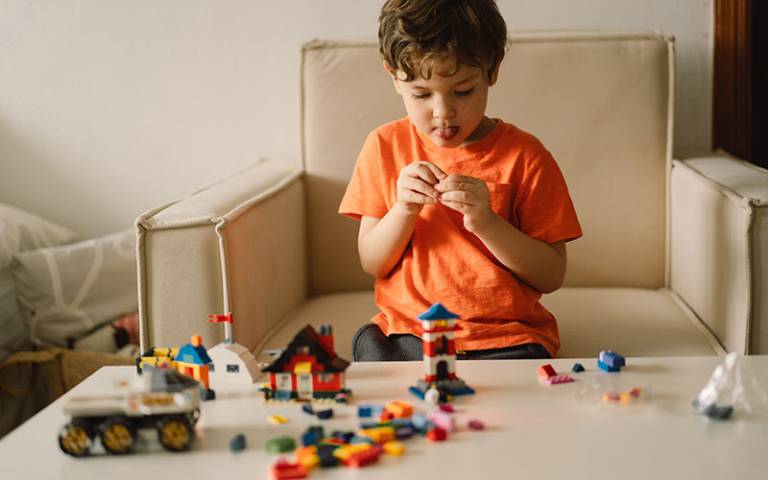Child playing with legos on couch. Image credit: Анастасія Стягайло via Adobe Stock.