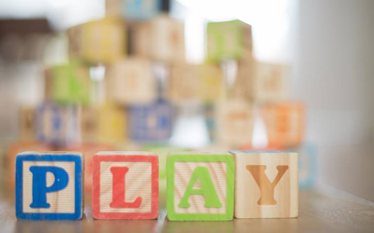 Wooden alphabet blocks spelling the word 'play'