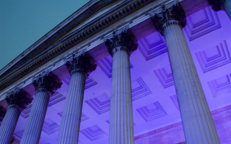 Ornate ceiling of the UCL Portico lit in purple