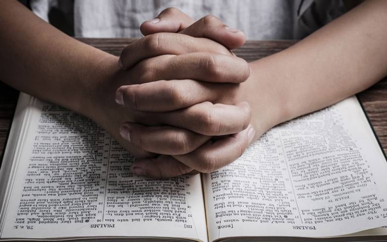 Person praying with bible open
