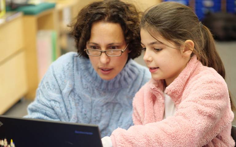 Teacher and primary pupil looking at laptop. Image: Phil Meech for UCL Institute of Education