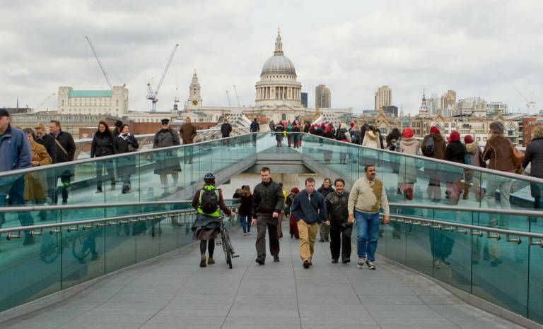 People walking over Millennium Bridge in London