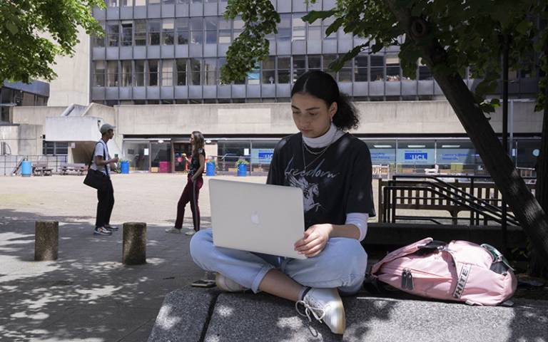 Student on laptop outside IOE. Image: John Cobb for UCL Institute of Education