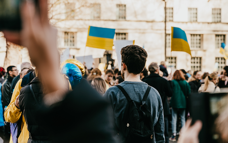 Young people in a crowd holding Ukrainian flags. Gina / Adobe Stock