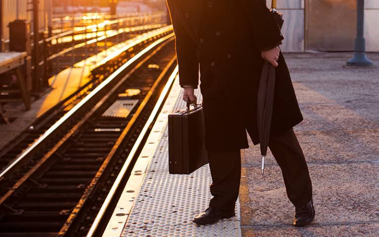 Person in business suit waiting on railway platform for train. (Photo: Cavan for Adobe)