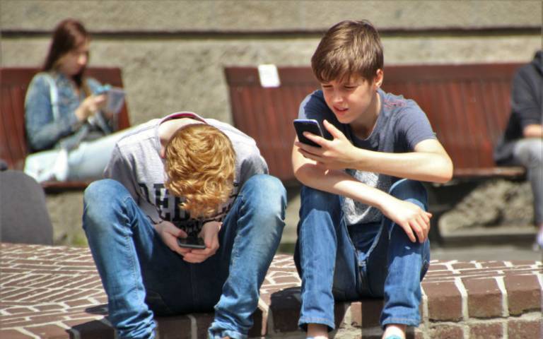Two young boys playing with phones. Image credit: Pexels