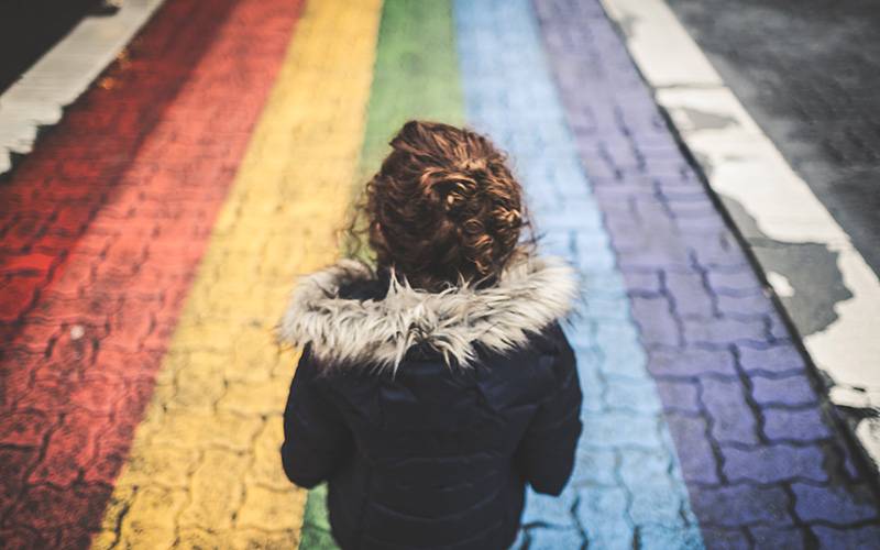 Child on a rainbow painted road. Image: Cory Woodward via Unsplash