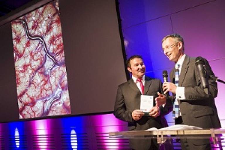 Derek Tutssel receiving the Wellcome Image Award 2012 from Fergus Walsh of the BBC