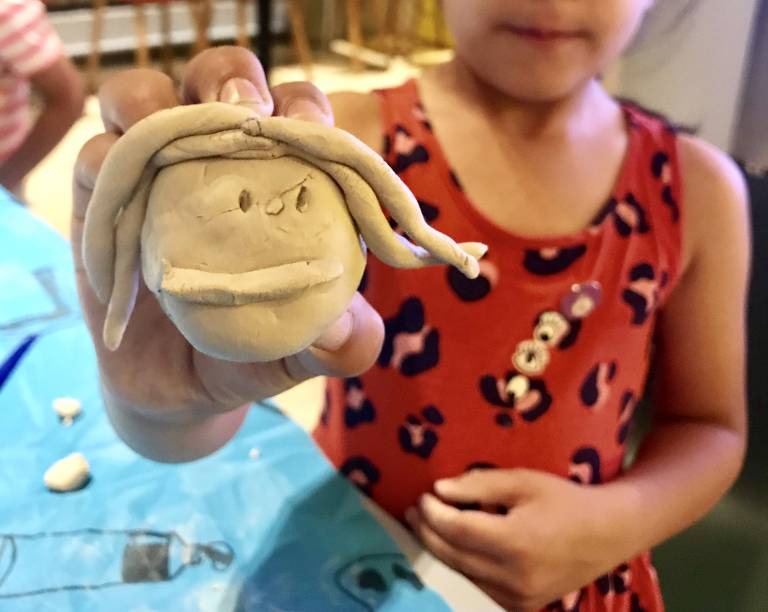 Image of girl holding eye made out of clay 