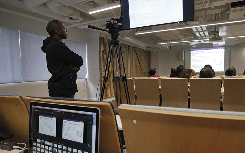 Picture of a student looking at a screen in a lecture hall