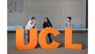 people standing behind giant letters U, C and L spelling UCL