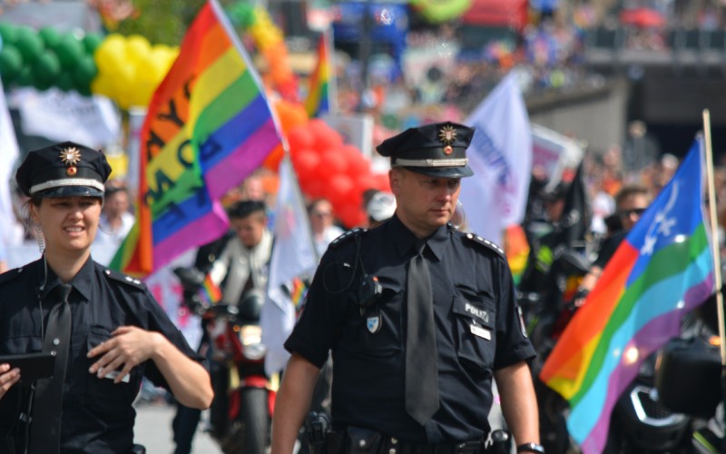 Diverse police with LGBTQ rainbow flag