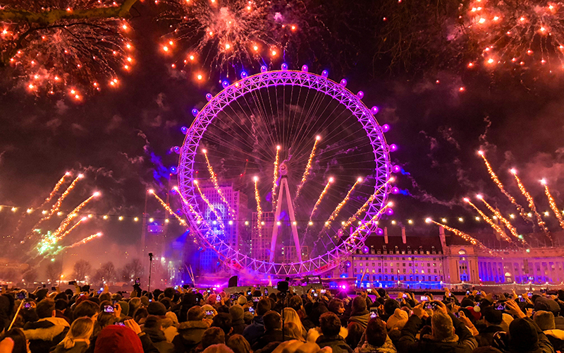 Fireworks at the London Eye on New Years' Eve with a crowd watching