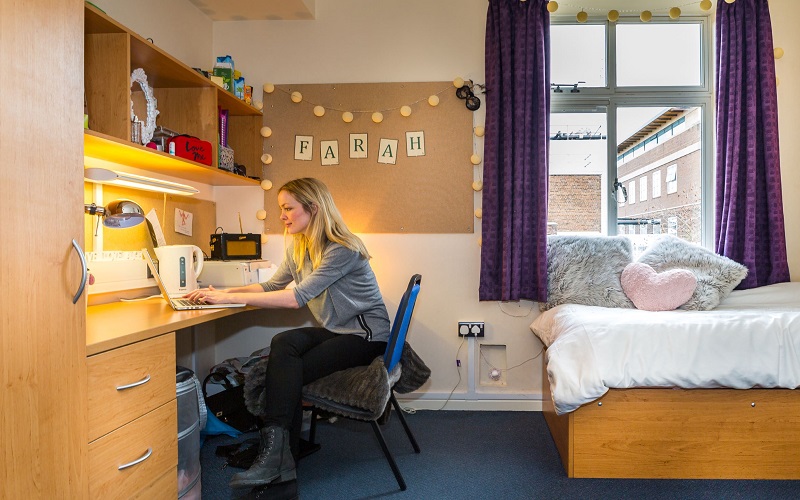 A student on her laptop in her UCL accommodation room
