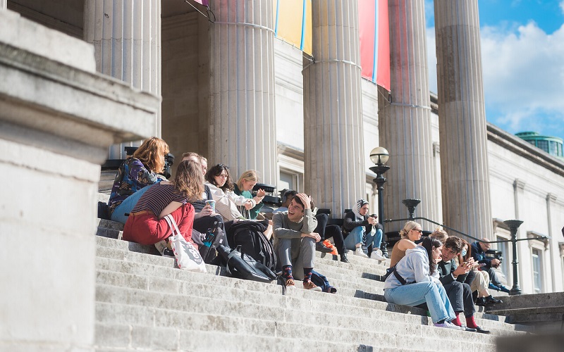 Students sat talking on the steps of the UCL portico building