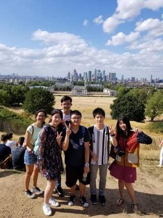 Mitsuru on a Pre-University social activity to Greenwich, posing with other students and a chaperone with the London Skyline in the background