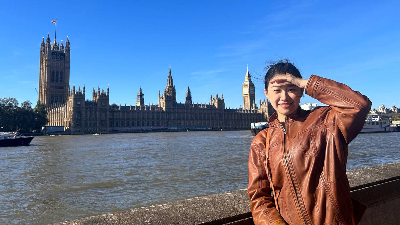 Jiafei standing by the River Thames with the Palace of Westminster in the background