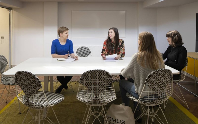 Four people sitting around a table and talking