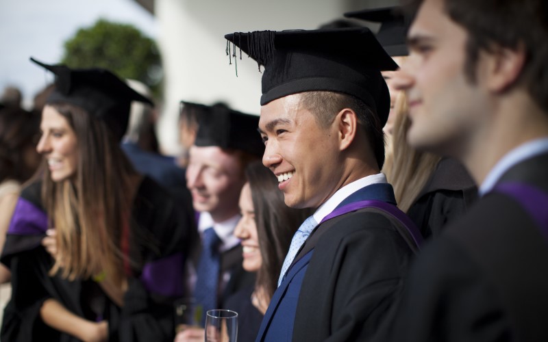 A graduate smiling at the camera