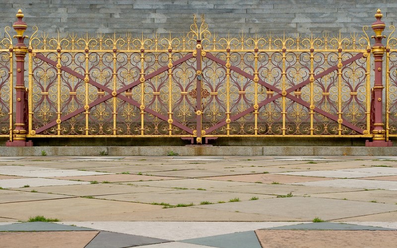 Decorative metal gold coloured railings at a gate in front of the Prince Albert memorial in Hyde Park