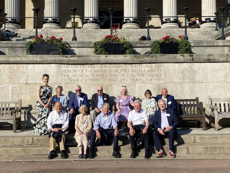 UCL Laws alumni sitting in front of the Portico steps with Professor Eloise Scotford on the left