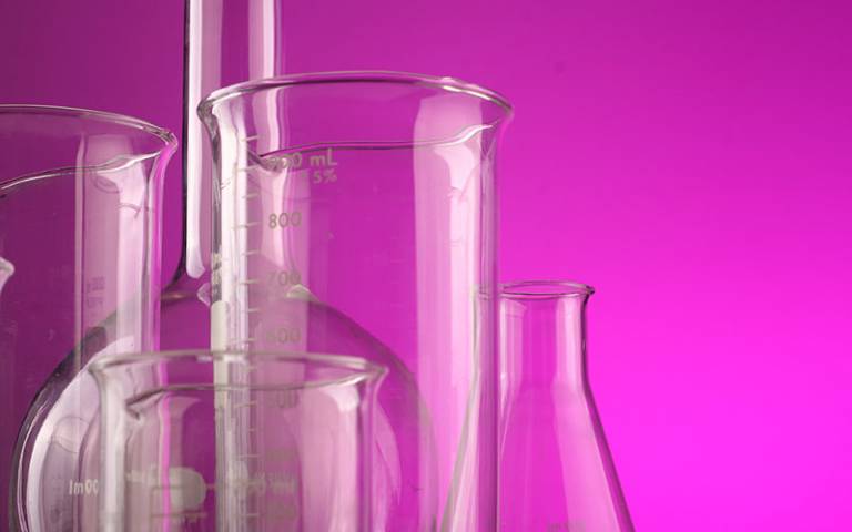pink background with glass science beakers