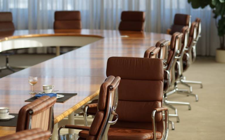image of a boardroom table with executive chairs