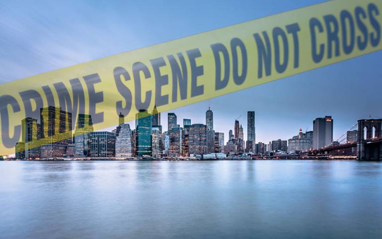 Image; cityscape with police crime tape across the centre of the image